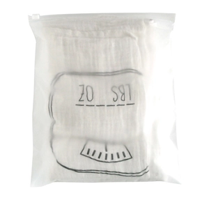 Close-up of white baby milestone blanket with LBS OZ weight scale in a matte zipper bag