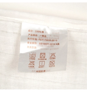 Detail of 100% cotton gauze baby blanket label showing Class A safety standards