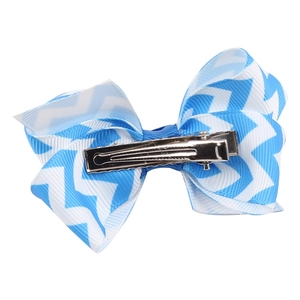 Detail view of wavy blue bow hair clip showing sturdy silver metal alligator clip on back