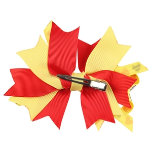 Detail showing the layered red and yellow grosgrain bow hairpin with metal duckbill clip