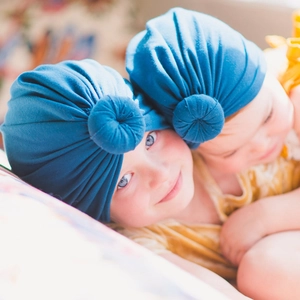 Detailed view of elastic newborn turban hats with donut knot design in peacock blue color