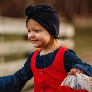 Close-up of baby navy blue knit turban hat with a stylish donut knot detail