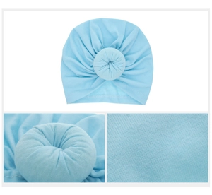 Close-up of light blue baby turban hat featuring a donut knot and soft knit texture
