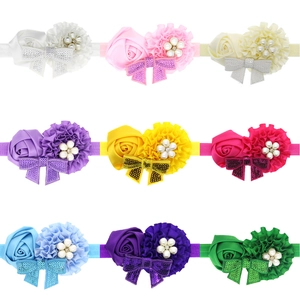 Nine colorful baby elastic headbands with satin roses, sequins bows, and pearls on white background