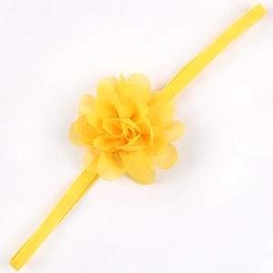 Dettaglio di un fiore di chiffon giallo brillante su una fascia elastica per neonati
