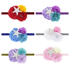Close-up of six starfish headbands in various colors with floral chiffon and pearls