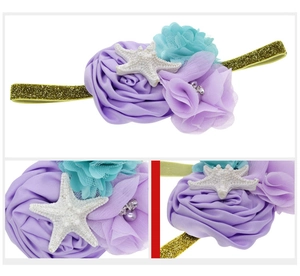 Close-up of baby starfish headband with silk roses, pearls and gold glitter elastic band