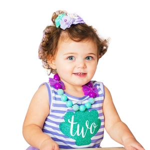 Starfish headband and mermaid-themed two-year-old birthday outfit with beaded necklace