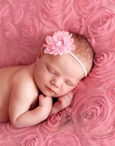 Dettaglio di un neonato con fascia per capelli con fiore in chiffon rosa per foto