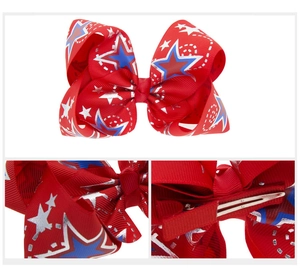 Détail du nœud en gros-grain rouge avec motifs d'étoiles bleues et pince crocodile en métal