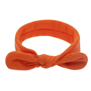 Détail d'un bandeau pour bébé en tissu côtelé orange avec un nœud papillon