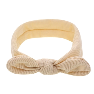 Détail d'un bandeau bébé en maille côtelée avec un grand nœud couleur crème