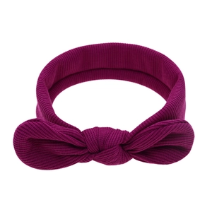 Gros plan du bandeau bébé en maille côtelée violet foncé avec un nœud papillon souple