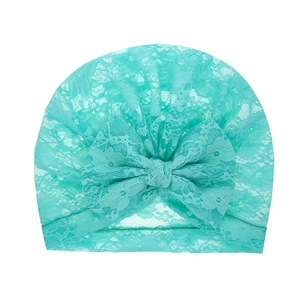 Mint green lace baby turban hat with floral embroidery and a large bow on white background