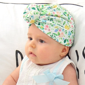 Detail of floral baby turban hat with donut knot on infant model in soft cotton