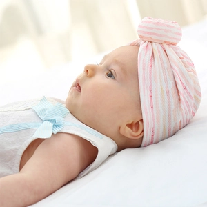 Detail of pink and white striped baby turban with a soft knit knot ball texture