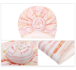 Detail of pink striped baby turban hat showing the donut knot and fine stitching quality