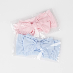 Detail von rosa und blauen gerippten Baby-Stirnbändern mit Schleifen in Verpackung