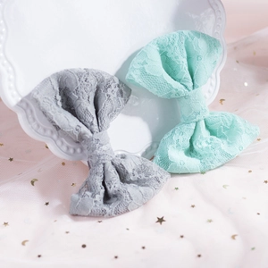 Dettaglio di fermagli per capelli in pizzo grigio e menta su piatto decorativo