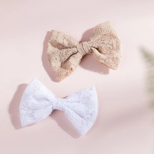 Dettaglio di eleganti fermagli per capelli a fiocco in pizzo con motivi floreali raffinati