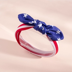 Close-up of soft cotton American flag baby headband with striped bow and stars