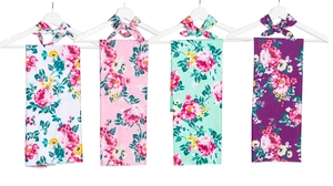 Detail showing four sets of floral printed baby swaddle blankets on white hangers