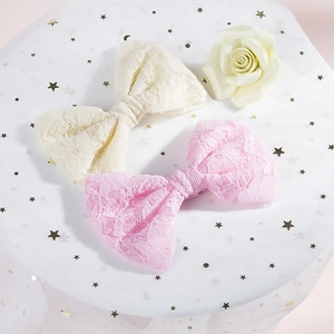Dettaglio di fermagli per capelli a fiocco in pizzo all'uncinetto beige e rosa