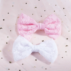 Dettaglio di fermagli per capelli con fiocchi in pizzo floreale rosa e bianco su tulle