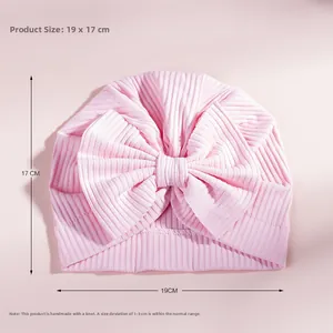 Pink cotton baby turban hat with large bow detail and 19x17cm dimension specs