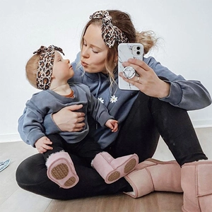 Close-up of mother and daughter in leopard headbands and grey daisy hoodies