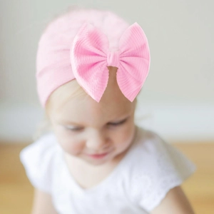 Pink ribbed cotton baby turban hat with a large bow for infants and toddlers