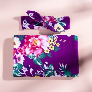 Detail of floral baby swaddle blanket and matching headband set in purple floral print