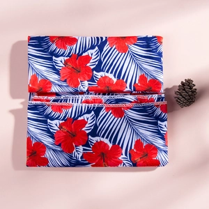 Gros plan du tissu de robe de maternité avec fleurs d'hibiscus et couture blanche
