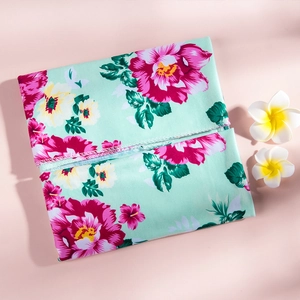 Detailed close-up of a floral print headband in mint green with rose pink blossoms