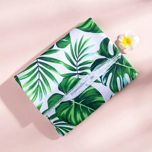 Close-up of tropical palm leaf print fabric with high-quality white overlock stitching detail