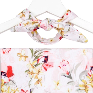 Détail du tissu rose clair avec motifs floraux rouges et jaunes pour robe de maternité
