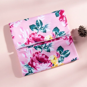 Detailed view of pink floral baby swaddle blanket with premium hemmed edge and soft fabric