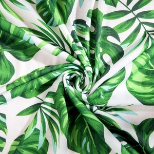 Macro shot of tropical leaf print fabric showing soft texture and vibrant green Monstera