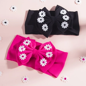 Détail de bandeaux bébé côtelés avec grands nœuds et petites fleurs marguerites