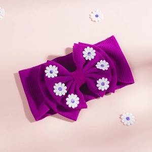 Détail du bandeau violet bébé avec broderie marguerite sur un grand nœud en relief