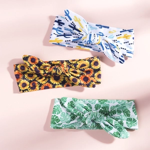 Flat lay of three baby bow headbands with cactus, sunflower and green leaf floral prints