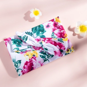 Detailed view of floral knit baby headband and matching wrap with soft pink floral print