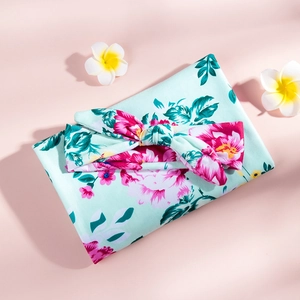 Detail of floral swaddle blanket and matching bow headband set for newborns
