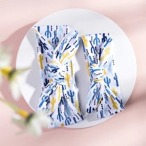 Detail view of cactus print rabbit ear headbands for mother and baby on a decorative plate
