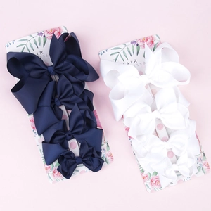 Detail of navy and white grosgrain ribbon bow clips set on floral display cards