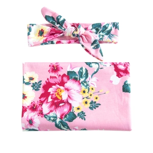 Floral print baby swaddle blanket and matching bow headband set in soft pink color