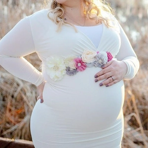 Detail of white V-neck maternity dress with elegant handmade floral sash and pearls