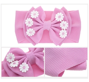 Détails du bandeau rose pour bébé avec texture gaufrée et nœud brodé de marguerites