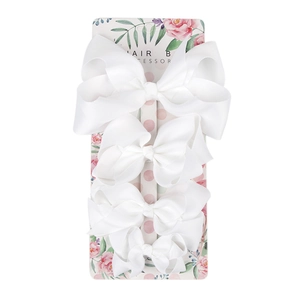 Set of four white grosgrain ribbon hair bows in different sizes on floral display card