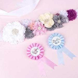 Detail of baby shower flower sash with Mommy and Daddy to be badges for gender reveal